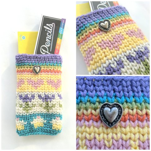A collage of three images of the same crocheted pouch in pastel colors with hearts, flowers, cupcakes, and a rainbow on it. Left photo is of pouch with a pencil box and yellow envelope in it. Top right photo is a close-up that shows the front of the pouch. Bottom right is a close-up of the metal filigree heart button.